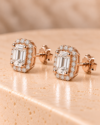 Tilt view of emerald halo diamond stud earrings in rose gold