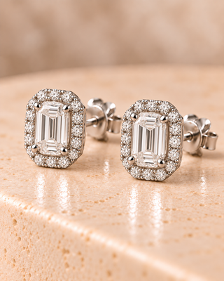 Tilt view of emerald halo diamond stud earrings in white gold