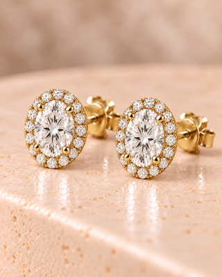 Tilt view of oval halo diamond stud earrings in yellow gold